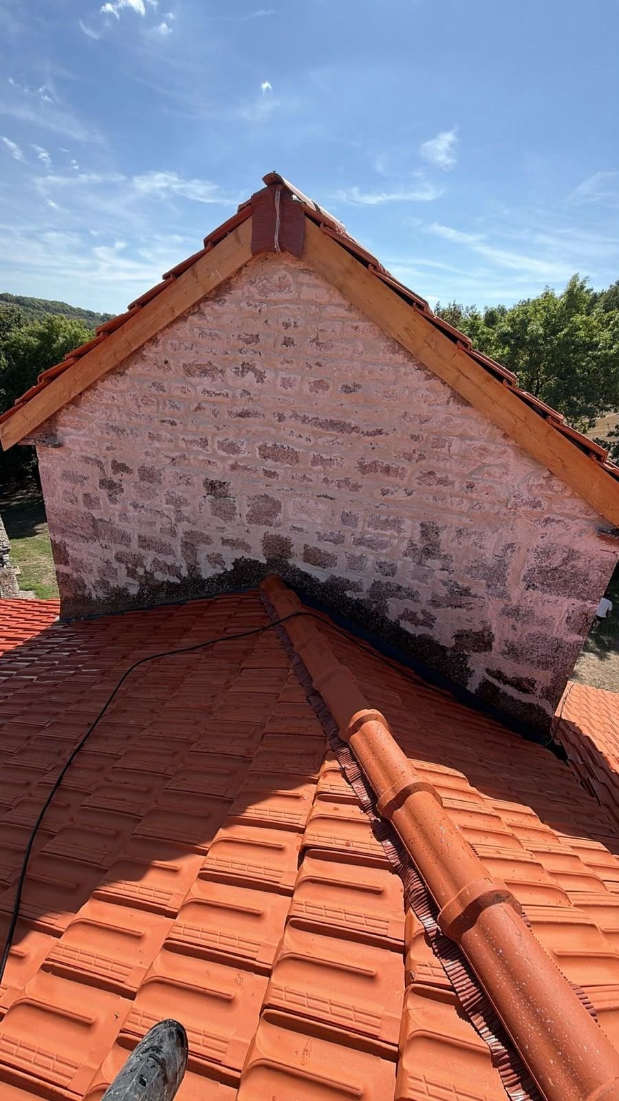 Faîtage et arêtier neufs vus du dessus, tuiles alignées et scellées en ligne de crête.